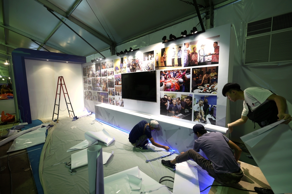 Workers preparing an exhibit for the Madani government one year anniversary programme at the National Stadium Bukit Jalil, December 7, 2023. — Bernama pic 