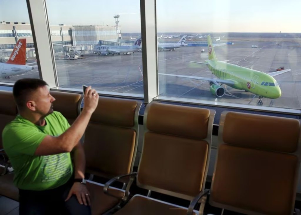 File picture shows a man taking pictures, with a plane (right) of S7 airlines seen in the background, at Domodedovo airport outside Moscow, Russia, November 6, 2015. — Reuters pic