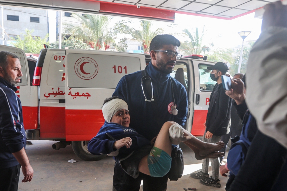 An injured Palestinian child is carried into a hospital following Israeli bombardment on Khan Yunis in the southern Gaza Strip on December 8, 2023, amid continuing battles between Israel and Hamas. — AFP pic 