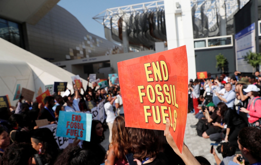 Climate activists protest against fossil fuels at Dubai's Expo City during the United Nations Climate Change Conference COP28 in Dubai December 8, 2023. — Reuters pic