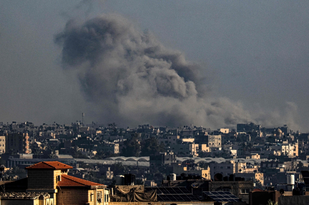A picture taken from Rafah shows smoke billowing above buildings during Israeli bombardment on Khan Yunis in the southern Gaza Strip on December 9, 2023, amid continuing battles between Israel and Hamas. — AFP pic