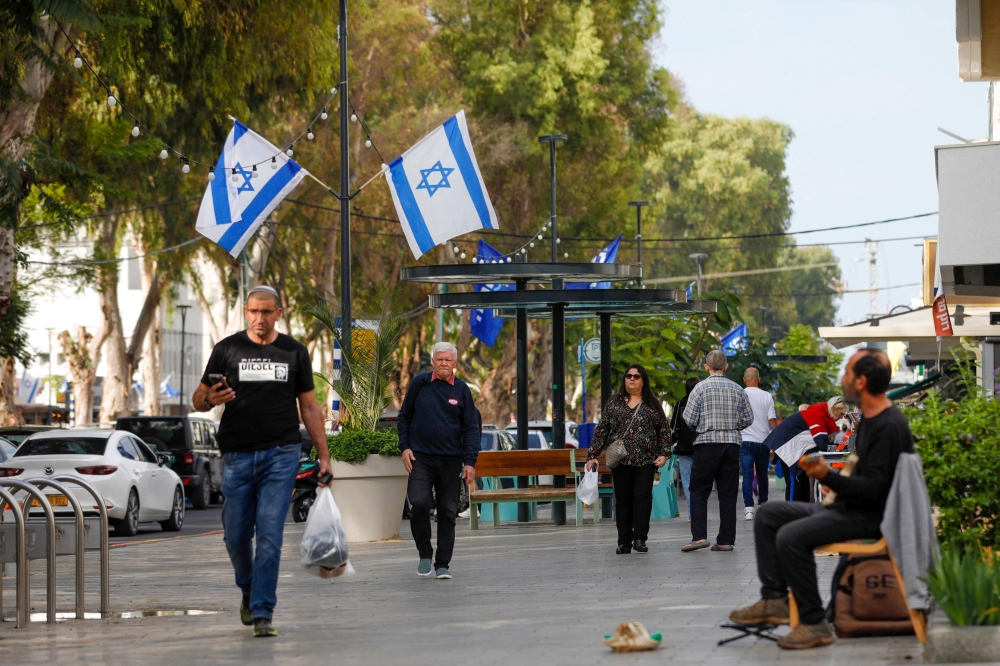 People walk in the northern Israeli city of Nahariya on December 8, 2023, amid ongoing cross-border tensions as fighting continues with Hamas militants in the southern Gaza Strip. — AFP pic