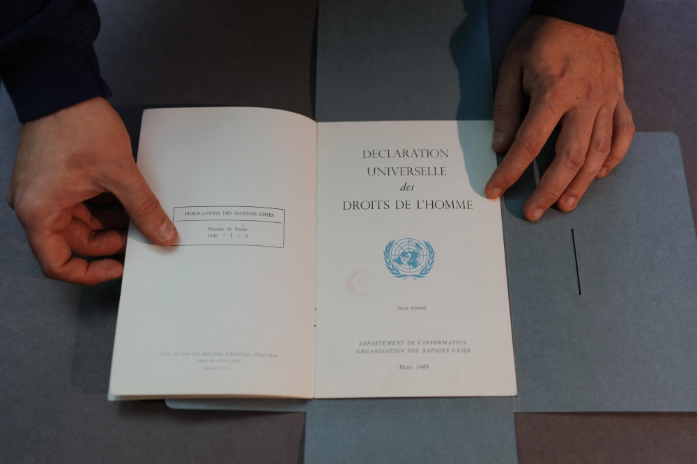 This photograph taken on December 9, 2023, shows a document from the Department of Information of the United Nations, dated March 1949, bearing the French text of the ‘Declaration Universelle des Droits de l’Homme’ (Universal Declaration of Human Rights) adopted and proclaimed by the General Assembly of the United Nations on December 10, 1948, displayed by an employee at the Bibliotheque Nationale de France in Paris. — AFP pic