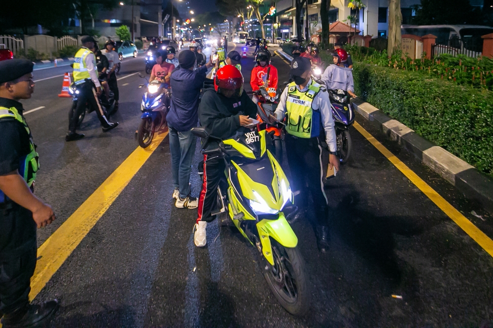 Police officers check on motorists going through Jalan Raja Laut, Kuala Lumpur in this file picture taken on July 8, 2023. A total of 113 motorcycles were seized and 334 summonses were issued in a special operation dubbed Op Samseng Jalanan, conducted along the North-South Highway near Taman Sama Gagah, Seberang Jaya early this morning. —Picture by Raymond Manuel