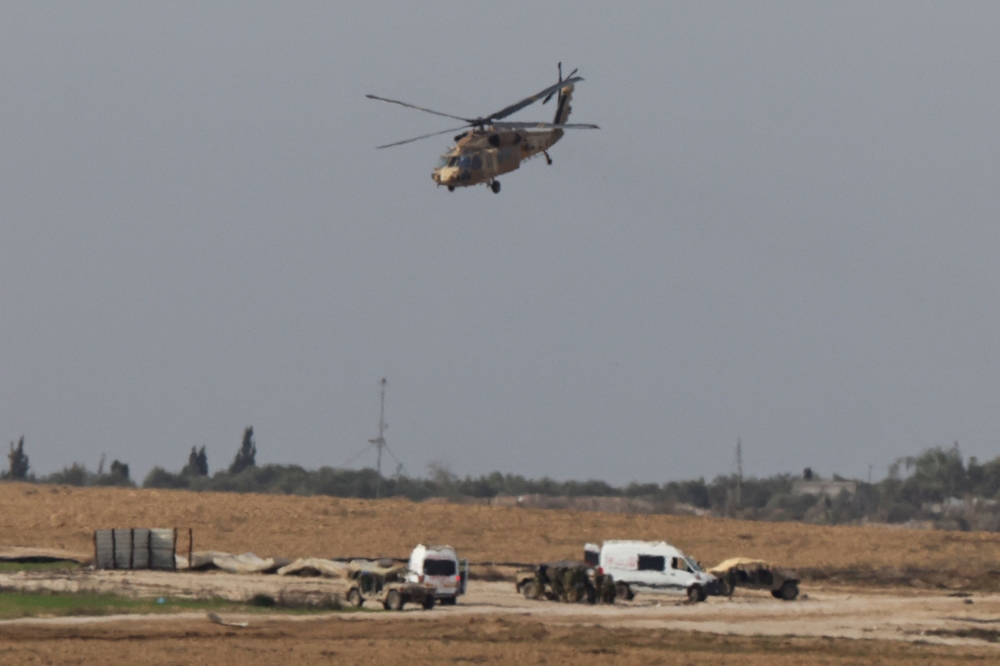 An Israeli helicopter flies near the Israel-Gaza border, amid the ongoing conflict between Israel and the Palestinian Islamist group Hamas, as seen from southern Israel, December 10, 2023. — Reuters pic