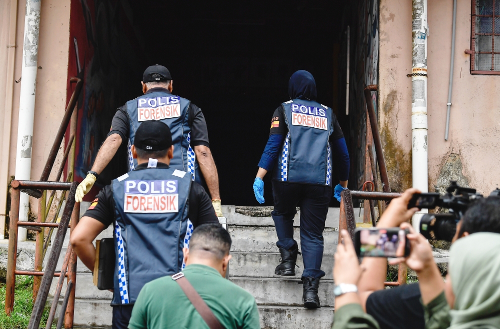 The team together with three other policemen in plain clothes were seen arriving at around 4.20 pm carrying a black box to the apartment on the second floor of the residential block. — Bernama pic