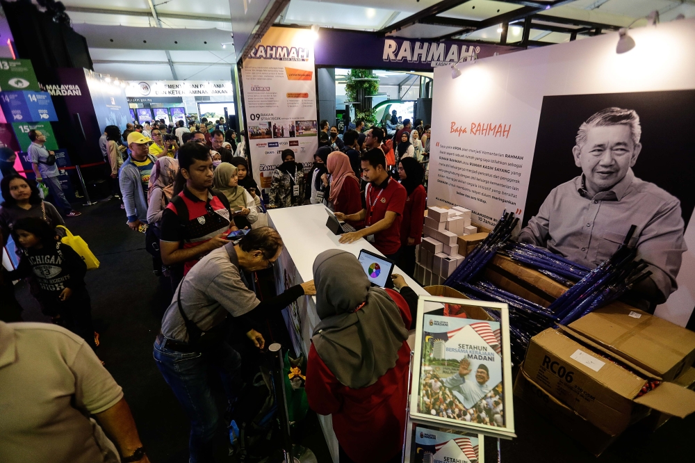 Visitors take part in the activities provided by the booths during the Madani Government One Year Anniversary Programme at the Bukit Jalil National Stadium December 10, 2023. — Picture by Sayuti Zainudin