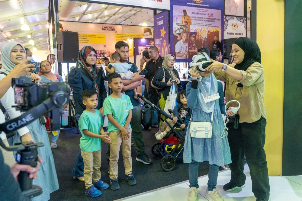 Visitors take part in the activities provided at booths by the government ministries and agencies during the Madani Government One Year Anniversary Programme at the Bukit Jalil National Stadium December 9, 2023. — Picture by Shafwan Zaidon