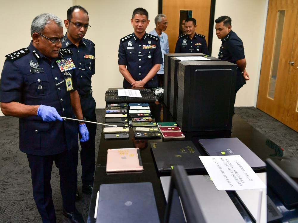 Director of the Bukit Aman Commercial Crime Investigation Department Datuk Seri Ramli Mohamed Yoosuf (left) showing items related to commercial crime that were exhibited at a press conference in Kuala Lumpur, December 11, 2023. — Bernama pic