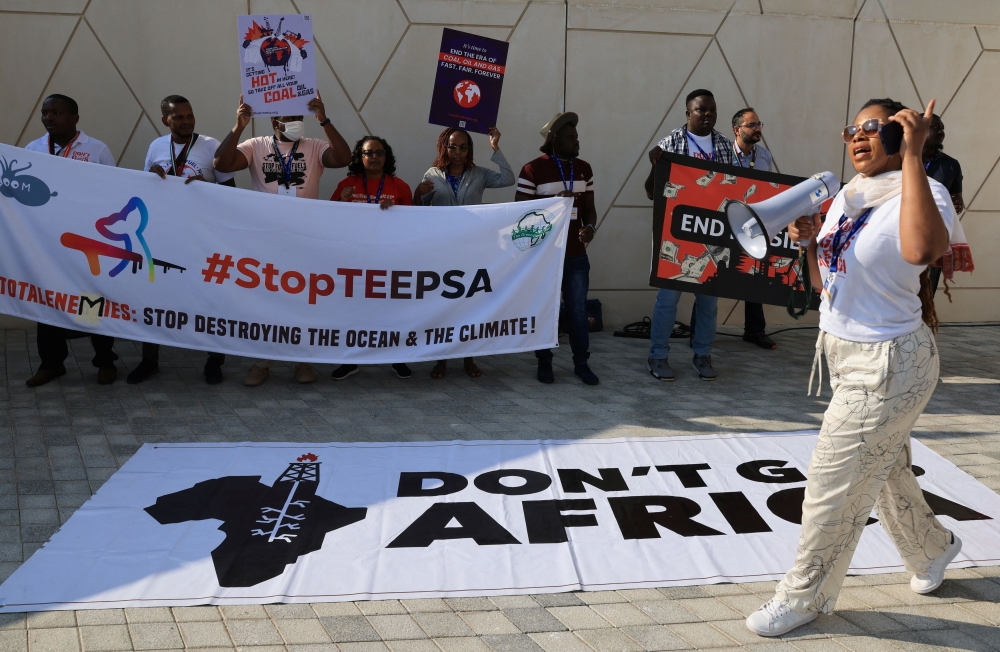 Activists hold placards and shout slogans during a protest ‘Kick TotalEnemies Out of Africa’ and against fossil fuels at the United Nations Climate Change Conference (COP28) in Dubai, United Arab Emirates, December 10, 2023. — Reuters pic  