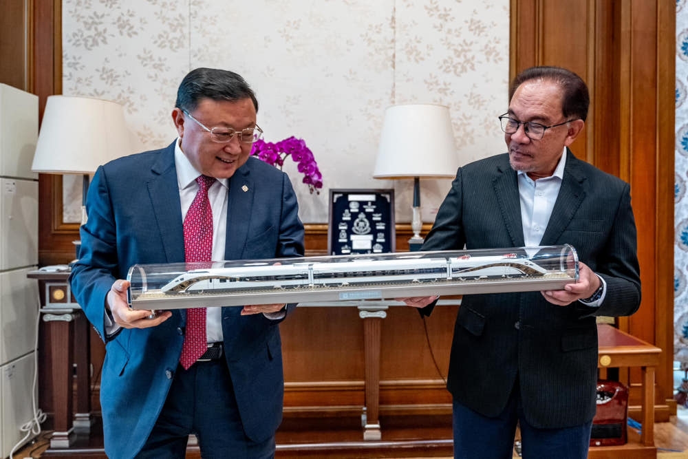 Prime Minister Datuk Seri Anwar Ibrahim and China Communications Construction Company (CCCC) chairman Wang Tongzhou pose with a model of the ECRL train in Putrajaya, December 12, 2023. — Picture from Facebook/Anwar Ibrahim 