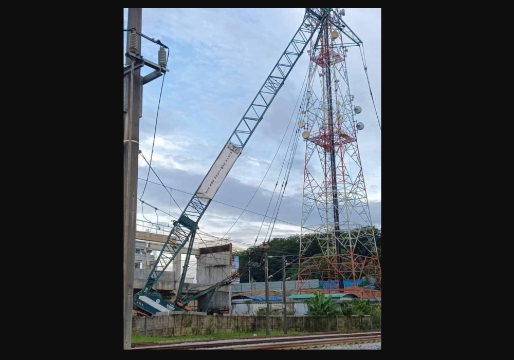 The collapsed crane. In a statement, KTMB did not state the location of the incident but said the incident caused both tracks of the Rawang-Tanjong Malim route to be obstructed. — Picture from social media 