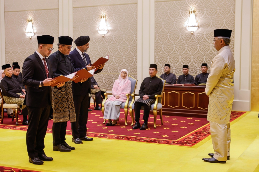 Yang di-Pertuan Agong Al-Sultan Abdullah Ri’ayatuddin Al-Mustafa Billah Shah witnesses (from left) Human Resources Minister Steven Sim Chee Keong, Health Minister Datuk Seri Dzulkefly Ahmad and Digital Minister Gobind Singh Deo take their oaths of office at Istana Negara, December 12, 2023. — Bernama pic 