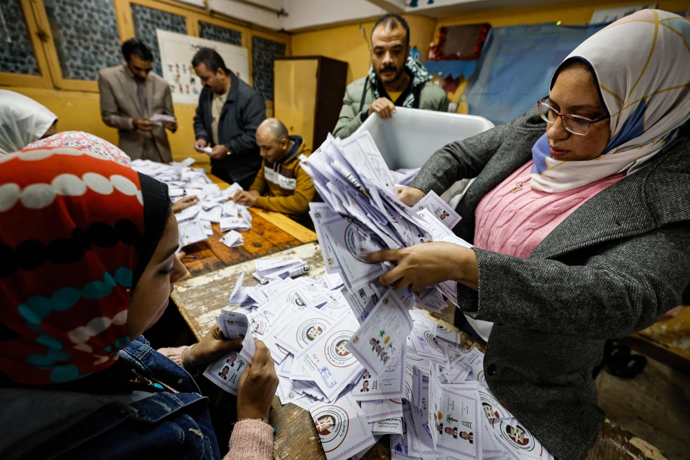 Election officials count the ballots at a polling station at Abdeen district in downtown Cairo December 12, 2023. — AFP pic