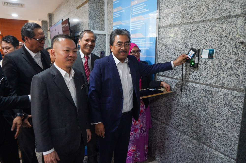 Plantation and Commodities Minister Datuk Seri Johari Abdul Ghani clocks in to start his official duties in Putrajaya December 13, 2023. — Picture by Shafwan Zaidon