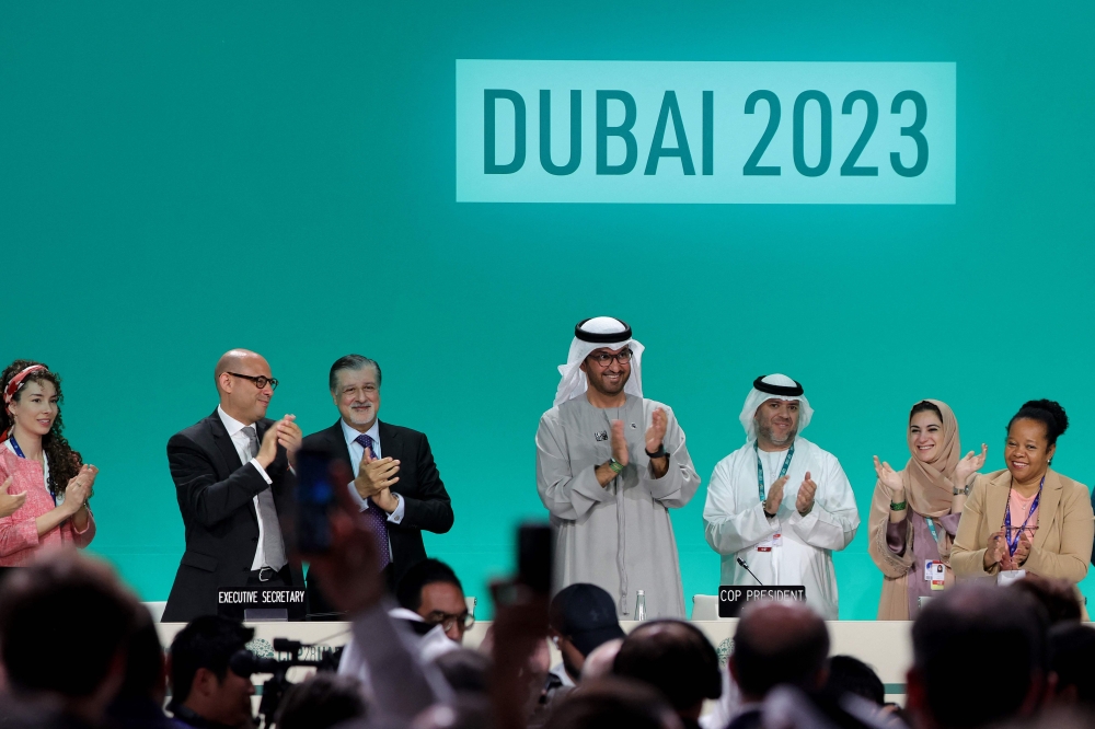 COP28 president Sultan Ahmed Al Jaber (centre) applauds among other officials before a plenary session during the United Nations climate summit in Dubai December 13, 2023. — AFP pic