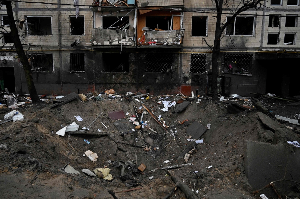 This photograph taken on December 13, 2023 shows a crater next to a residential building following a missile strike in Kyiv, amid the Russian invasion of Ukraine. — AFP pic
