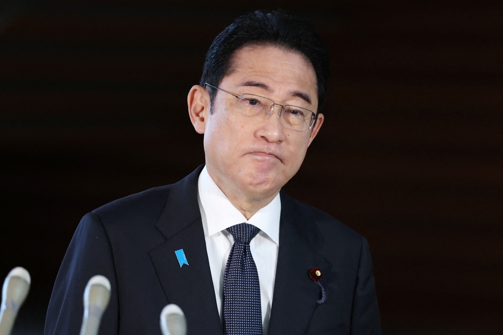 Japan's Prime Minister Fumio Kishida responds to reporters' questions upon his arrival at the prime minister's office December 11, 2023. — Jiji Press/AFP pic