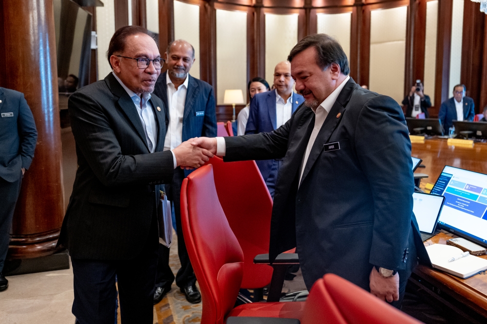 Prime Minister Datuk Seri Anwar Ibrahim and Finance Minister II Datuk Seri Amir Hamzah Azizan shake hands during the first Cabinet meeting with the new appointments today. — Picture by Afiq Hambali/Prime Minister’s Office of Malaysia