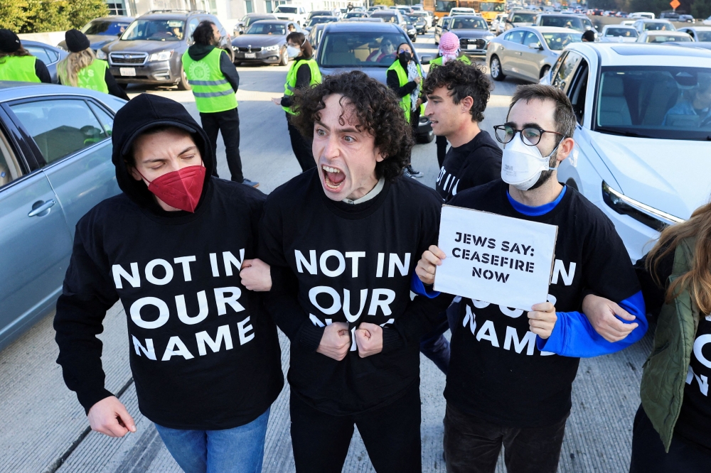 Protesters demanding a ceasefire and an end to US support for Israel’s attack on Gaza block morning traffic on the 110 Freeway, in Los Angeles December 13, 2023. — Reuters pic