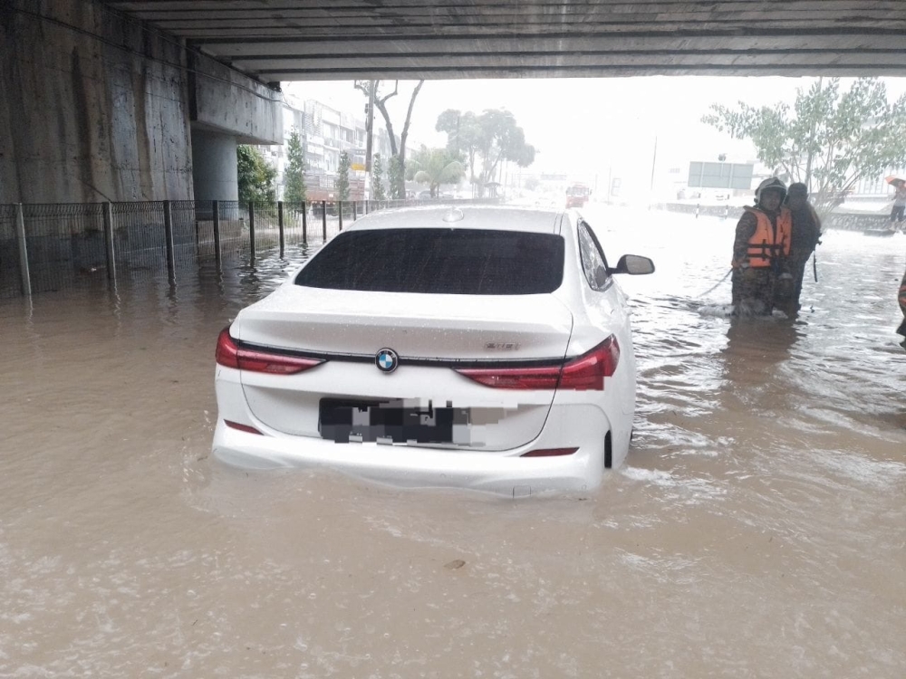 Firemen saved a elderly woman and a male youth after they were trapped in a BMW vehicle along Jalan Persiaran Molek Utama in Taman Molek, Johor Baru, December 14, 2023. — Picture courtesy of the Johor Fire and Rescue Department