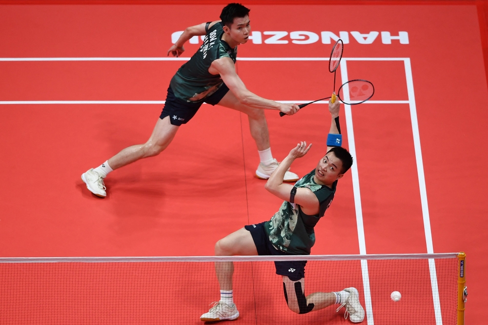 Malaysia’s Aaron Chia (right) and Soh Wooi Yik react after hitting a return to China’s Ou Xuanyi and Liu Yuchen  during their men’s doubles match at the BWF Badminton World Tour Finals in Hangzhou, in China’s eastern Zhejiang province on December 14, 2023. — AFP pic 