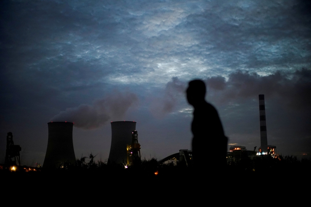A man walks past a coal-fired power plant in Shanghai October 14, 2021. Global consumption of coal reached an all-time high in 2023, the IEA energy watchdog said today, as Earth experienced its hottest recorded year. — Reuters pic