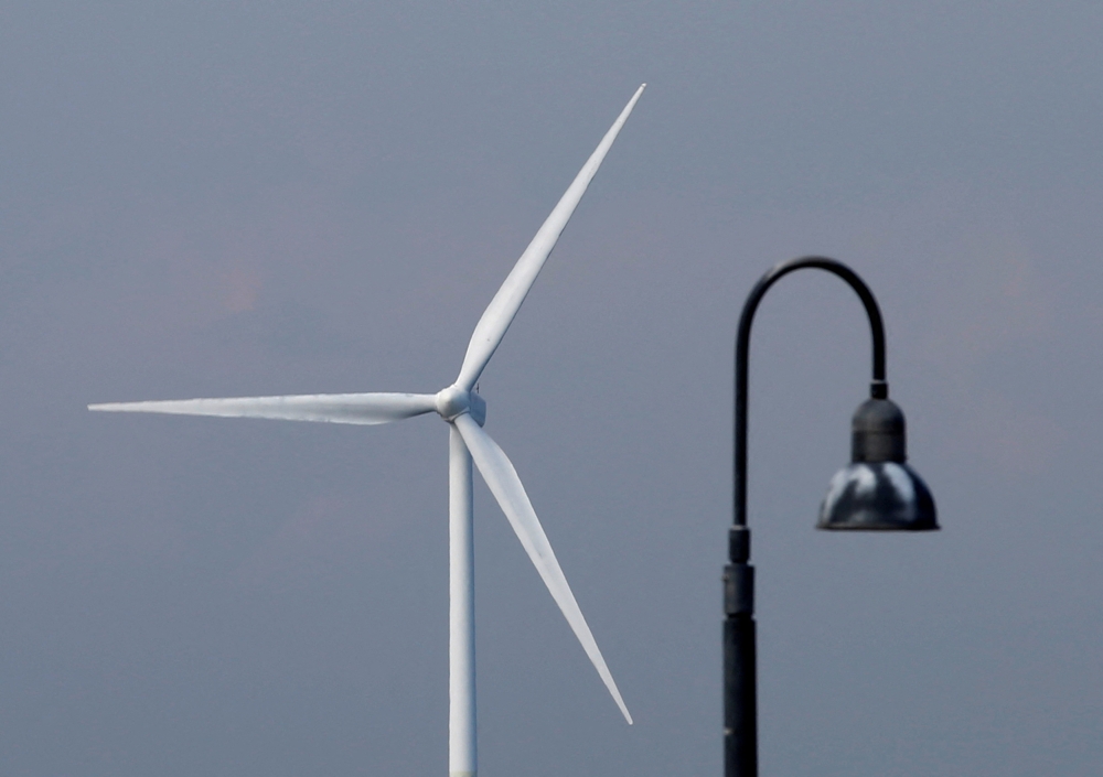 A wind turbine is seen behind a streetlamp in Yokohama, Japan August 9, 2017. — Reuters pic  
