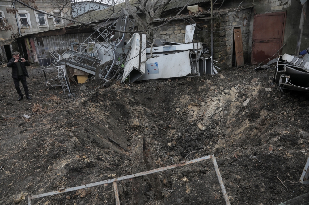 A man takes a picture of a crater that formed during Russian drone strikes, amid Russia’s attack on Ukraine, in Odesa, Ukraine December 14, 2023. ¬— Reuters pic