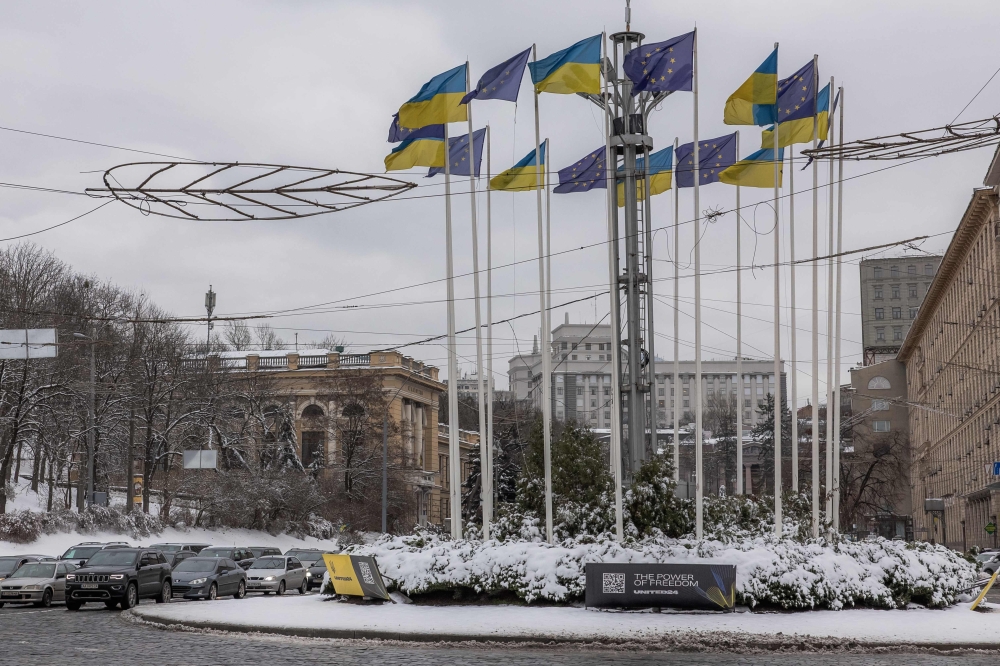 Cars drive past flags of Ukraine and European Union on the European Square in downtown Kyiv, on December 15, 2023, amid the Russian invasion of Ukraine. — AFP pic
