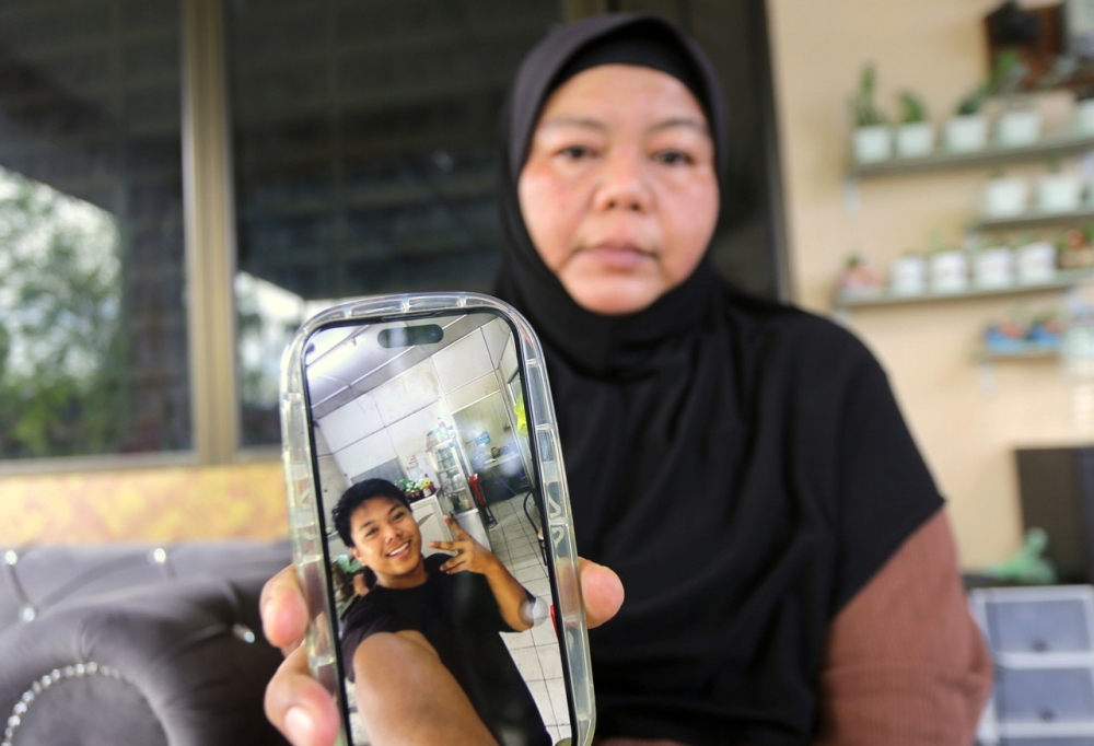 Mimi Julia Ismail, mother of the deceased, Muhammad Zaharif Affendi Muhd Zamrie, looking sad while showing a picture of her late son at her family’s residence in Taman Chepor Sentosa Chemor, Ipoh, December 16, 2023. — Bernama pic