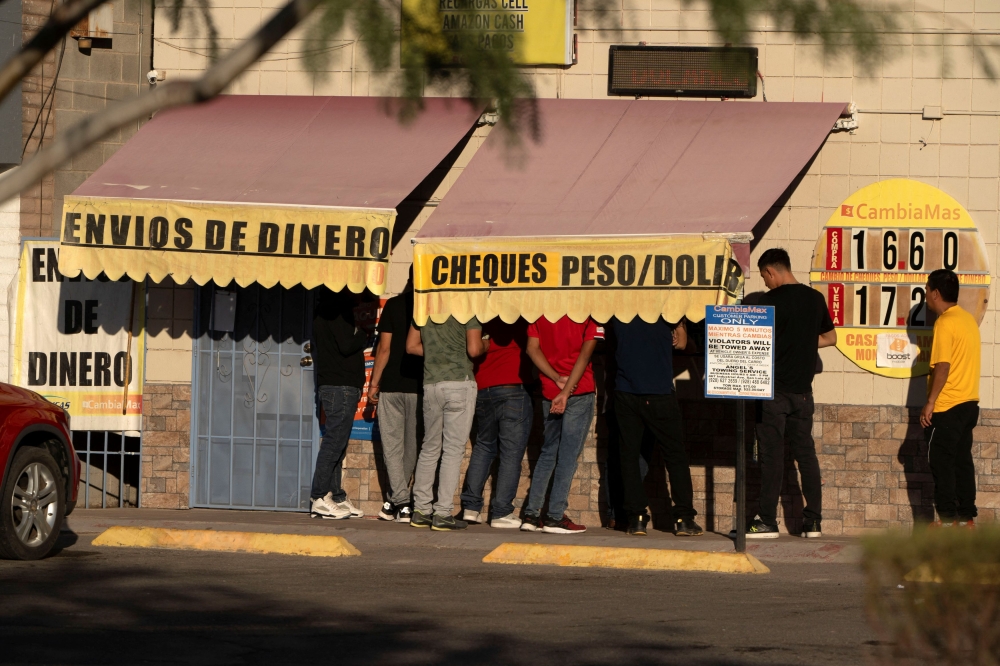 File photo of workers exchanging money, in the heavily Hispanic Yuma County, a Democratic stronghold in the southwestern corner of Arizona along the Mexico border, in downtown San Luis, Arizona, US, November 17, 2023. — Reuters pic