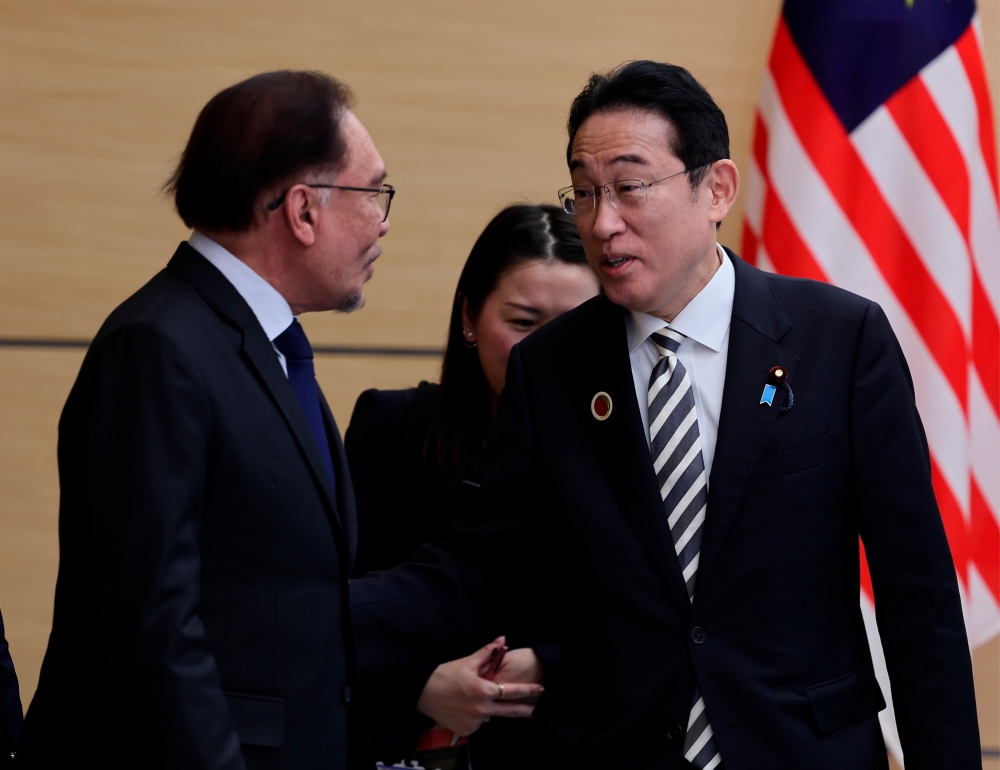 Malaysian Prime Minister Datuk Seri Anwar Ibrahim (left) having a light moment with his Japanese counterpart Fumio Kishida during their bilateral meeting at the latter’s office, December 16, 2023. — Bernama pic