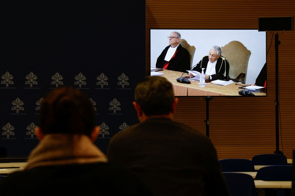 Journalists watch the Vatican corruption trial on a screen in a press room, at the Vatican, December 16, 2023. — Reuters pic