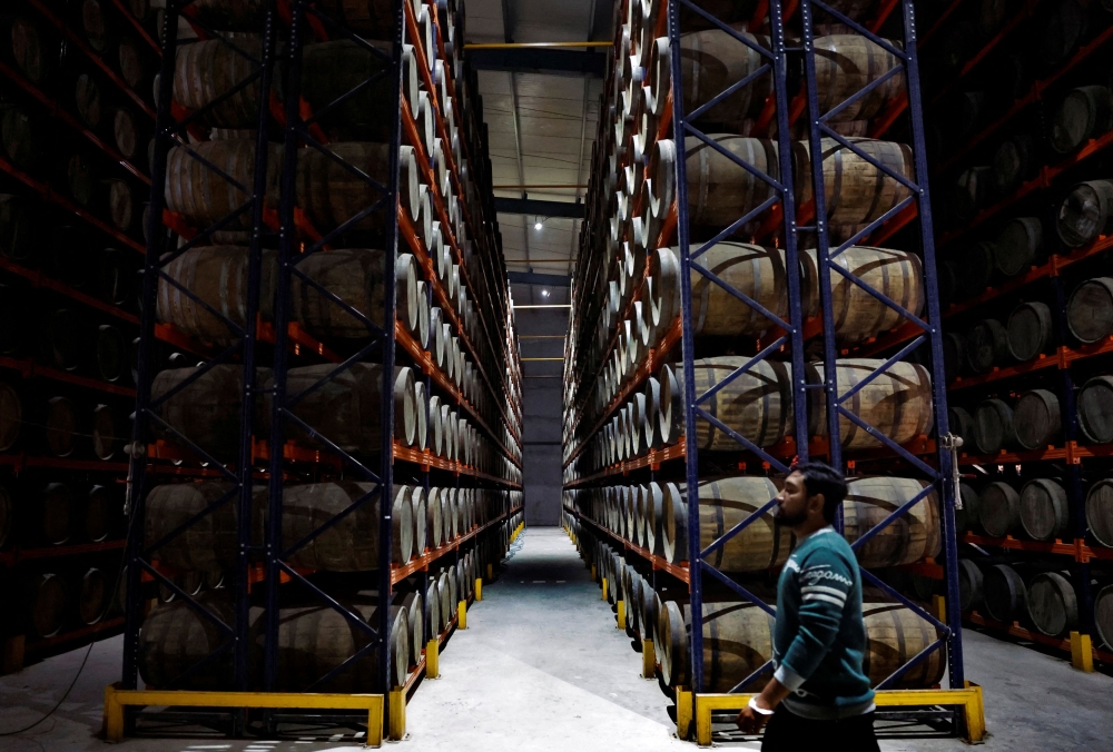 A worker walks past whisky barrels inside Piccadily Distilleries, in Indri, in the northern state of Haryana, India, December 14, 2023. — Reuters pic  