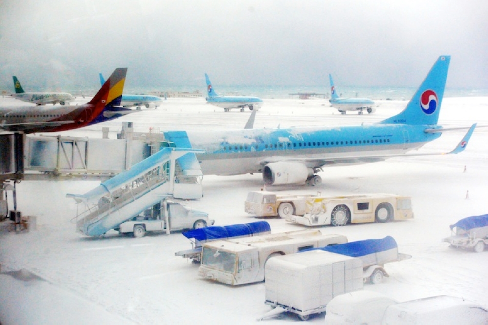 Planes are seen on the snow covered landing strip at Jeju International Airport on Jeju island in this file picture taken on January 24, 2016. A total of 12 flights were cancelled on the southern resort island of Jeju this morning, officials said, amid the cold wave and heavy snow. — Reuters pic