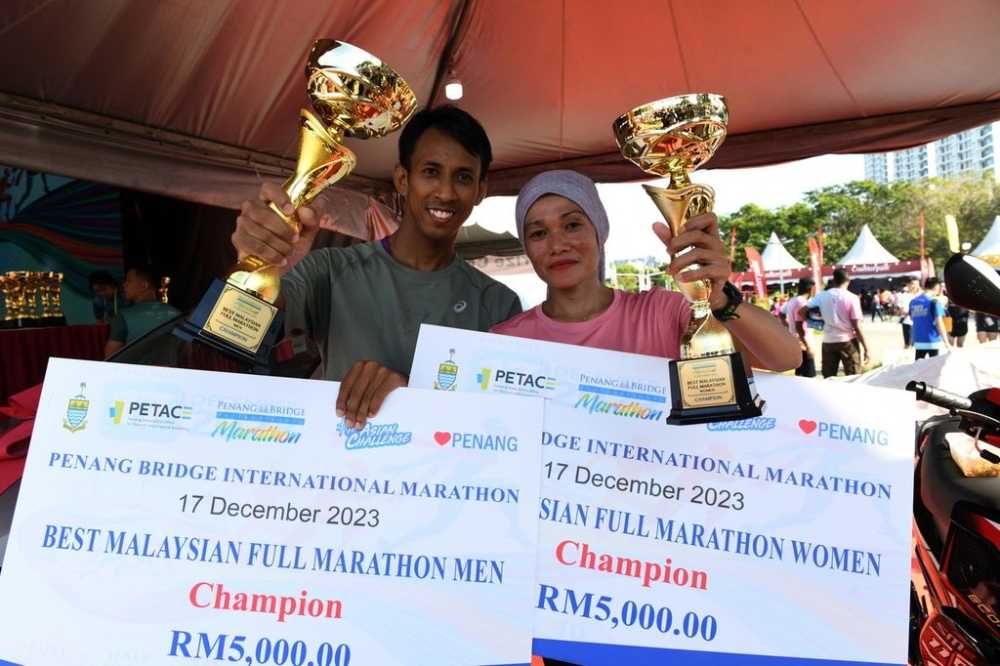 Husband and wife couple Nik Fakaruddin Ismail, 38, (left) and Noor Amelia Musa, 37, won the Best Malaysian Full Marathon Men and Best Malaysian Full Marathon Women events in the Penang Bridge International Marathon 2023 competition, December 17, 2023. — Bernama pic