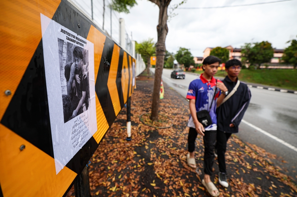 A poster of the late Mohammad Zaharif Affendi, 17, who died after being hit by a car, was put up at the scene of the crash at SMK Jati Secondary School, Taman Jati December 17, 2023. — Bernama pic