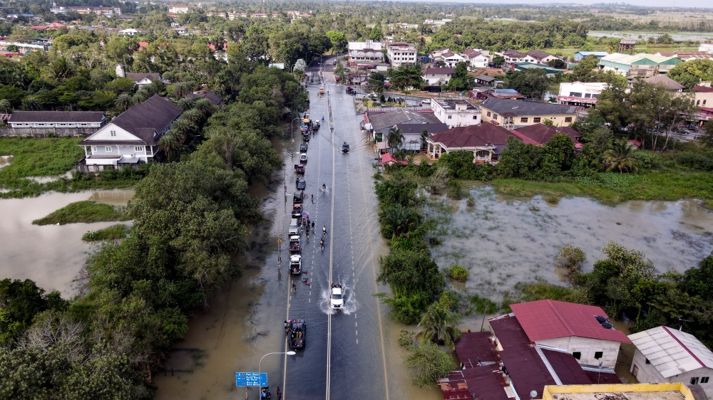 Vehicles traverse through floodwaters near a traffic light in Pekan Rantau Panjang in Pasir Mas, December 17, 2023. — Bernama pic 