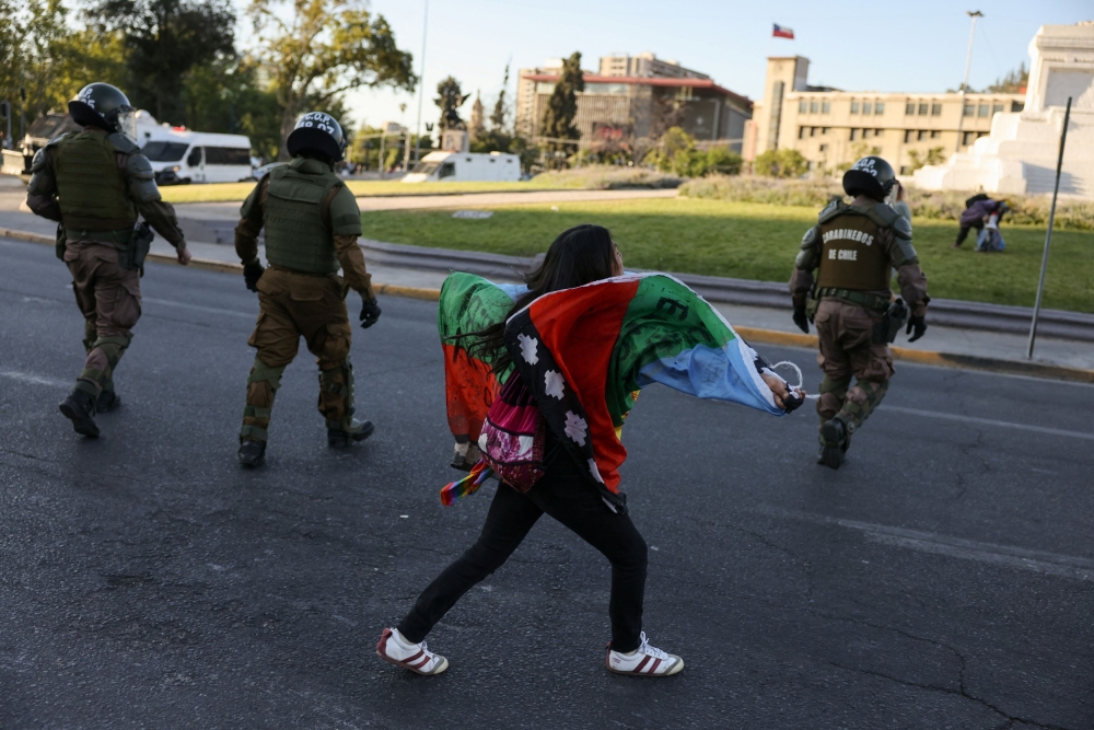 A woman yells at riot police officers as people attempt to celebrate after polls closed, on the day of the referendum on a new Chilean constitution in Santiago, Chile, December 17, 2023. — Reuters pic  