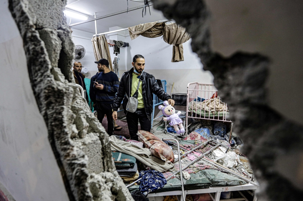 People inspect the damage in a room following Israeli bombardment at Nasser hospital in Khan Yunis in the southern Gaza Strip on December 17, 2023, amid ongoing battles between Israel and the Palestinian group Hamas. — AFP pic