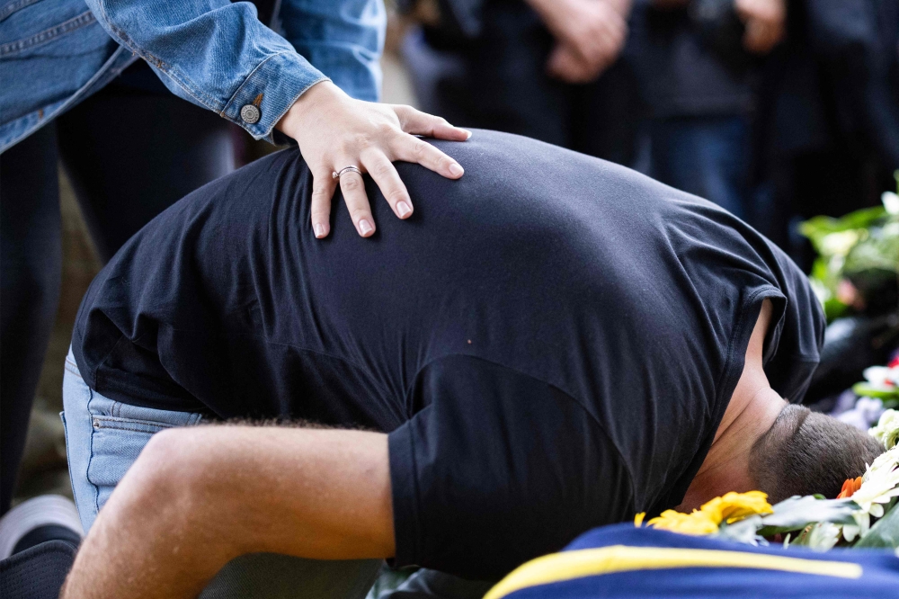 A relative mourns during the funeral of Alon Shamriz, mistakenly killed by Israeli forces in Gaza earlier in the week after being held by Hamas since the October 7 attack, in kibbutz Shefayim near Tel Aviv on December 17, 2023. The three hostages killed by Israeli soldiers in Gaza were shot even as they carried a white flag and cried for help in Hebrew, an army official said. — AFP pic