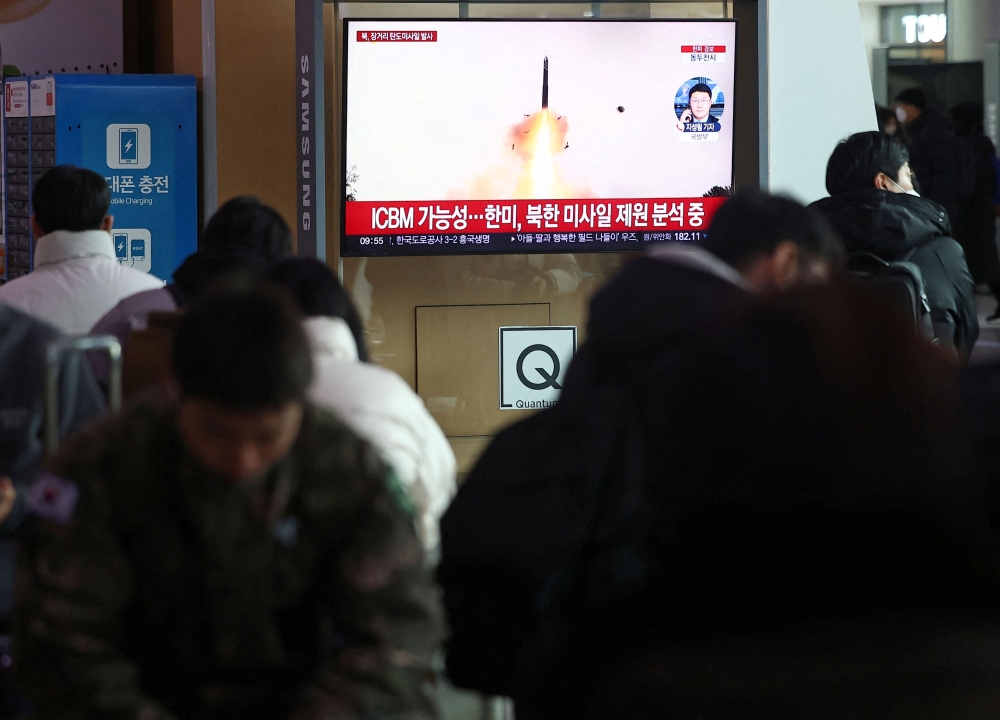 People watch a TV broadcasting a news report on North Korea firing what appeared to be a long-range ballistic missile, at a railway station in Seoul December 18, 2023. — Yonhap pic via Reuters