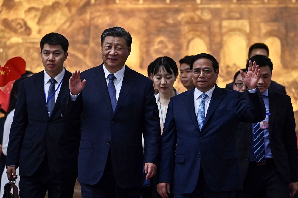 Vietnam's Prime Minister Pham Minh Chinh (centre right) bids farewell to China's President Xi Jinping (centre left) after their meeting at the Government Office in Hanoi December 13, 2023. — Nhac Nguyen/Pool/AFP pic 