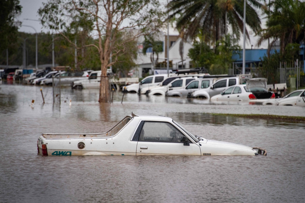 This picture shows cars amid floodwaters at Cairns Airport in Cairns on December 18, 2023. — AFP pic