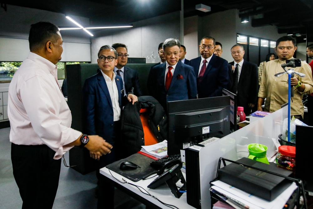 Communications Minister Fahmi Fadzil (second left) together with the Xinhua News Agency delegation visiting the newsroom during the Memorandum of Agreement Signing Ceremony between Bernama and Xinhua News Agency at Bernama headquarters in Kuala Lumpur, December 18, 2023. — Picture by Hari Anggara.
