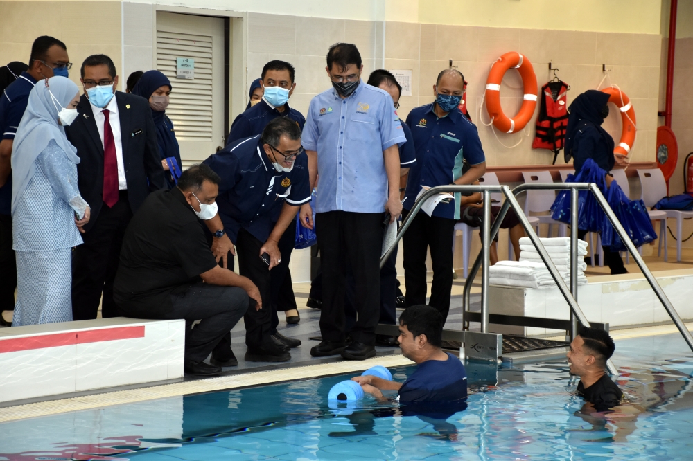 Deputy Minister of Transport Datuk Hasbi Habibollah (centre) speaks with an insured individual undergoing rehabilitation at the aquatic centre during a visit after officiating 2023 World Day of Remembrance for Road Traffic Victims at the Perkeso Tun Ab Razak Rehabilitation Centre in Melaka, December 19, 2023. — Bernama pic 