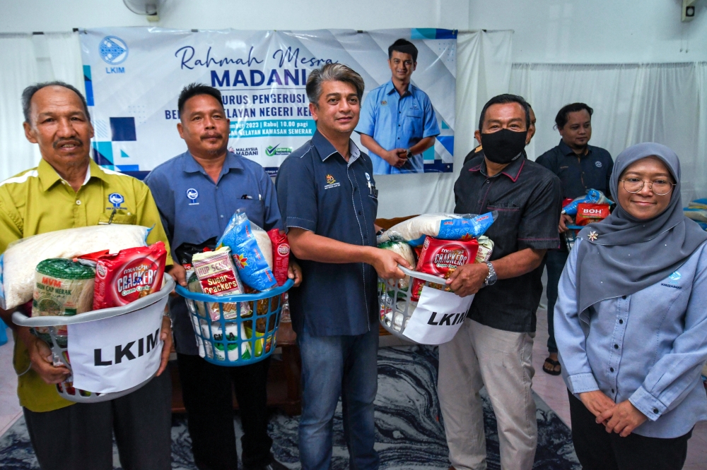 Fisheries Development Authority of Malaysia chairman Muhammad Faiz Fadzil (centre) presents a basket of food to the chairman of the association to be distributed to local fishermen at an engagement session with fishermen’s associations (PNK) in Pasir Puteh, Kelantan, December 20, 2023. — Bernama pic 
