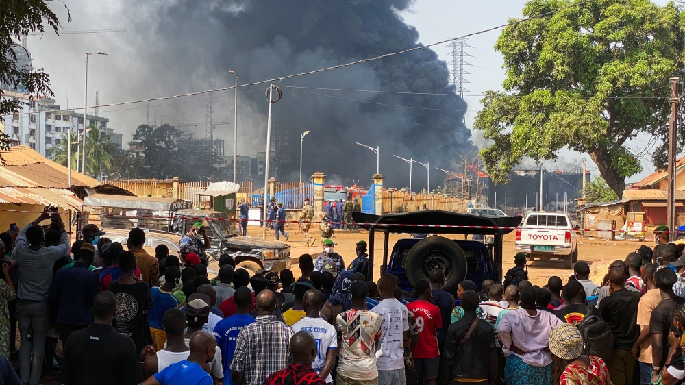 People look at the explosion site from behind the safety barrier after the blast at an oil terminal in Conakry, Guinea December 19, 2023. ― Reuters pic