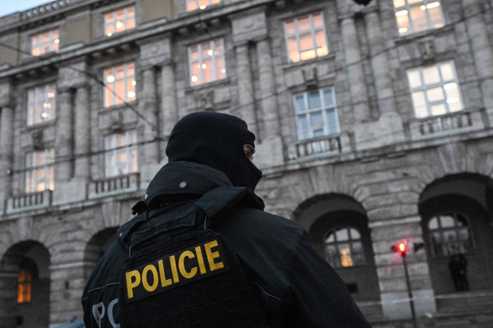 A police officer is seen in front of the Charles University in central Prague, on December 22, 2023 as police investigators kept working on the campus the day after a deadly mass shooting. — AFP pic